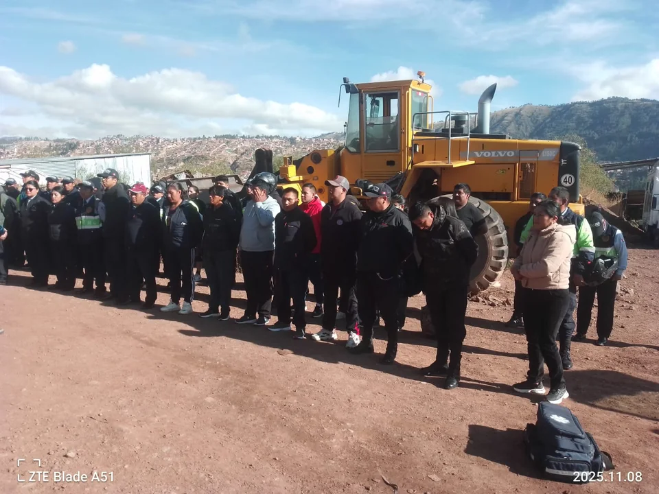 Personal y participantes en actividad de campo junto a maquinaria y entorno operativo